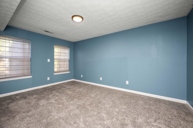 carpeted spare room with a textured ceiling