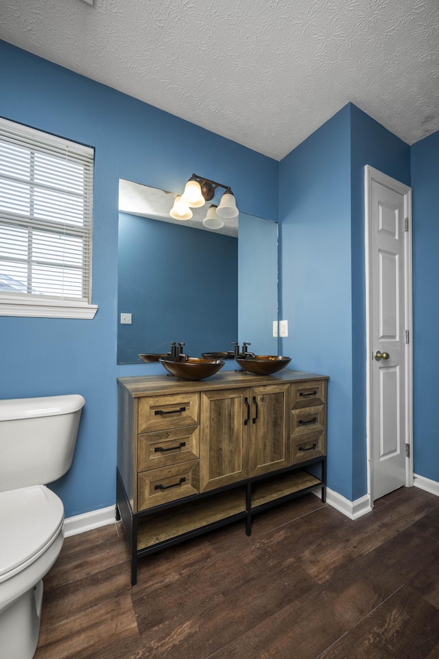 bathroom with hardwood / wood-style floors, vanity, and a textured ceiling