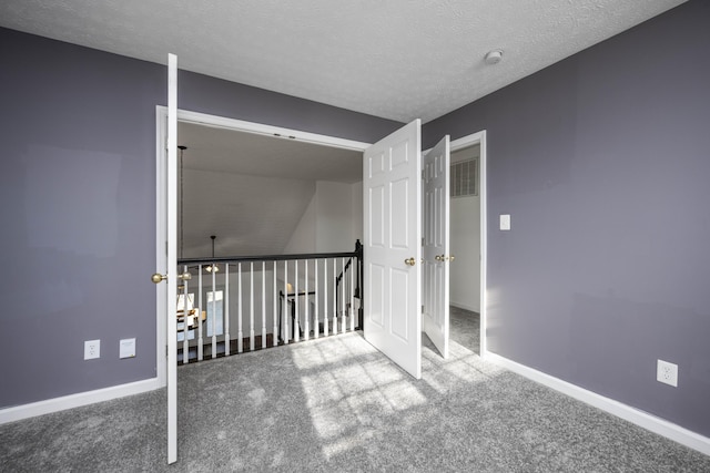 interior space with carpet floors and a textured ceiling