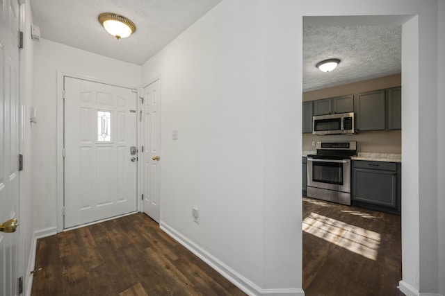 entrance foyer with a textured ceiling and dark hardwood / wood-style flooring