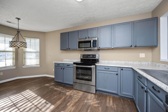 kitchen featuring dark hardwood / wood-style flooring, a textured ceiling, stainless steel appliances, blue cabinets, and decorative light fixtures