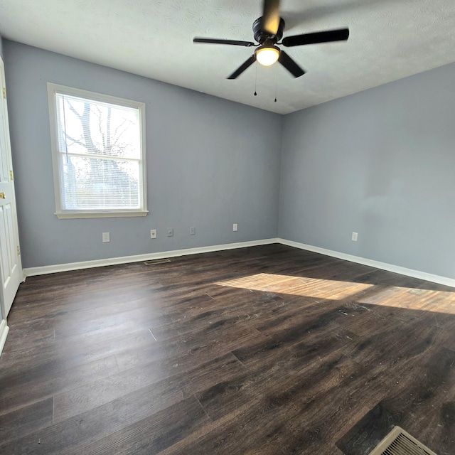 unfurnished room with ceiling fan, dark hardwood / wood-style flooring, and a textured ceiling