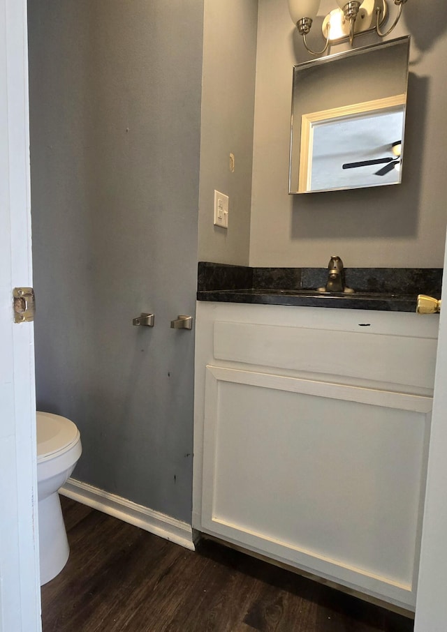 bathroom featuring wood-type flooring, toilet, and vanity