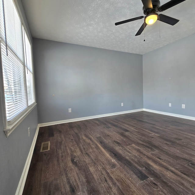 unfurnished room featuring dark hardwood / wood-style flooring, a wealth of natural light, and a textured ceiling