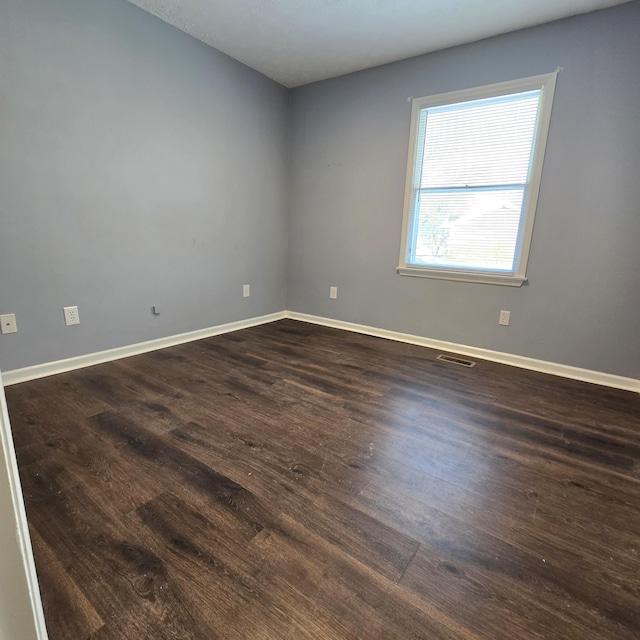 spare room with dark wood-type flooring