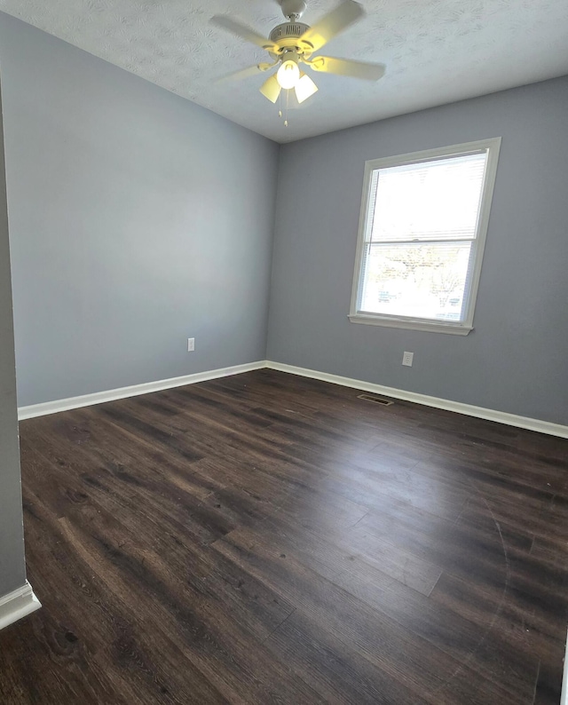 spare room with dark hardwood / wood-style flooring, ceiling fan, and a textured ceiling