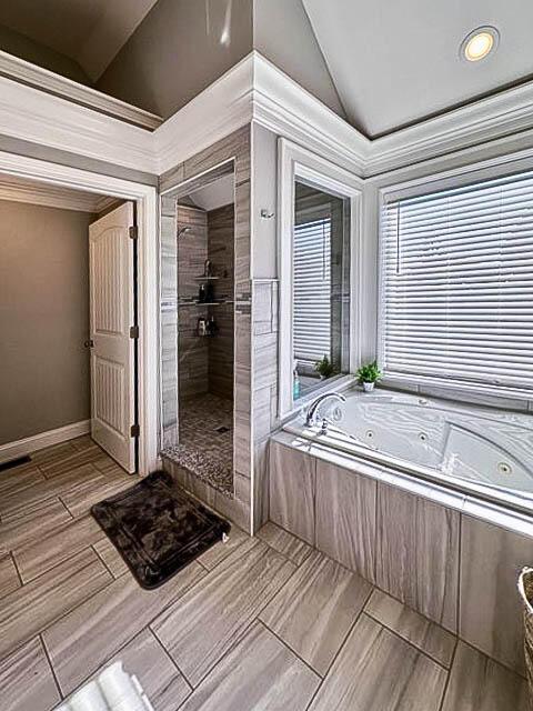 bathroom featuring separate shower and tub and vaulted ceiling