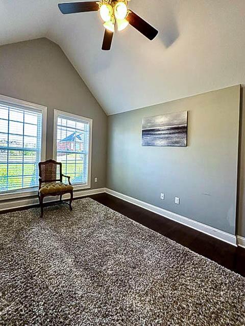 unfurnished room with ceiling fan, dark hardwood / wood-style flooring, and lofted ceiling