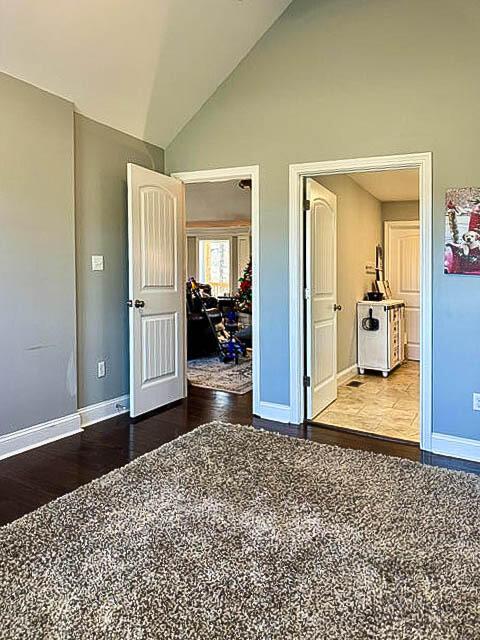 unfurnished bedroom featuring hardwood / wood-style flooring and high vaulted ceiling