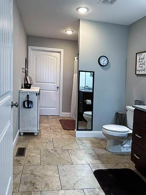 bathroom featuring vanity, curtained shower, and toilet