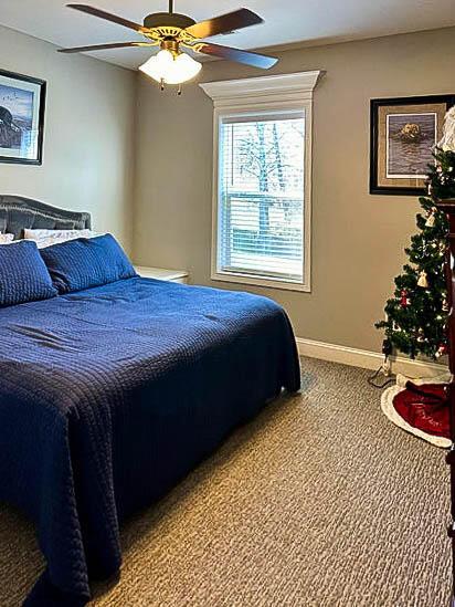 bedroom featuring light carpet and ceiling fan