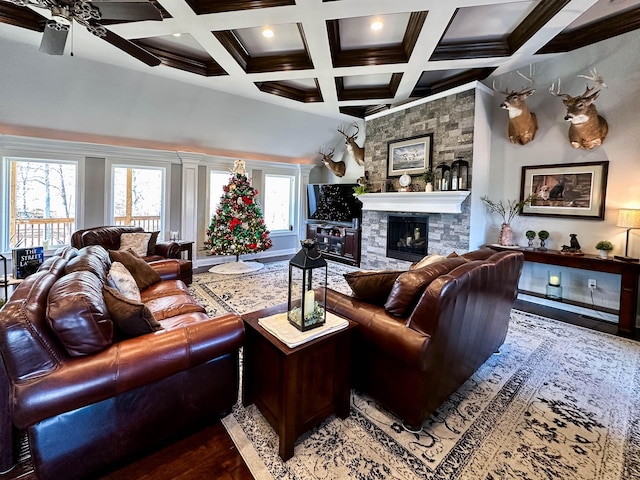 living room with beamed ceiling, a stone fireplace, wood-type flooring, and coffered ceiling