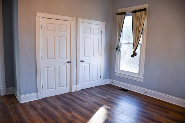 unfurnished bedroom featuring dark hardwood / wood-style flooring