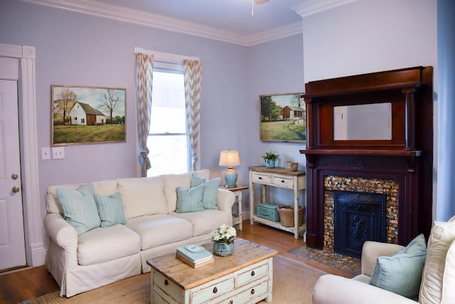 living room featuring hardwood / wood-style floors, ornamental molding, and a tiled fireplace