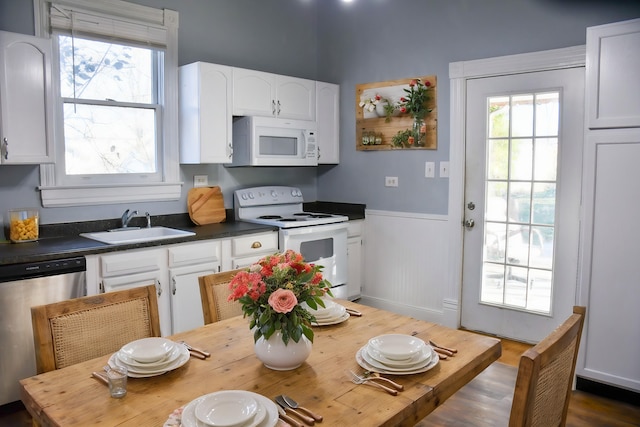 kitchen featuring white cabinetry, dark hardwood / wood-style flooring, white appliances, and sink