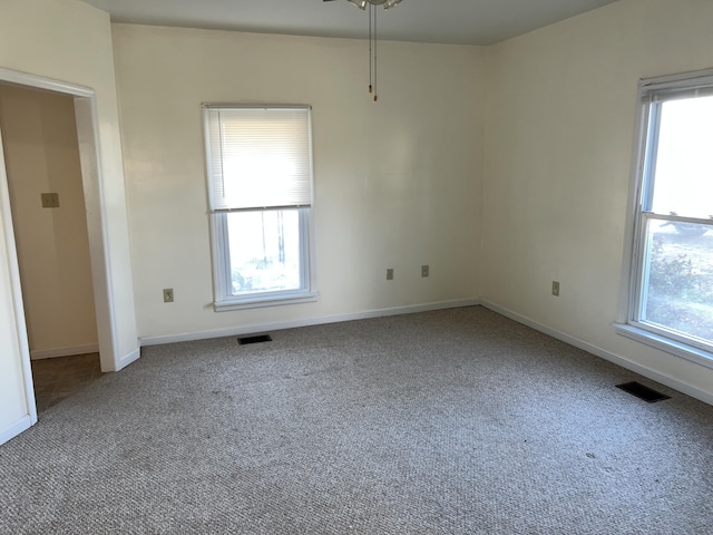 unfurnished room featuring carpet flooring, ceiling fan, and a wealth of natural light