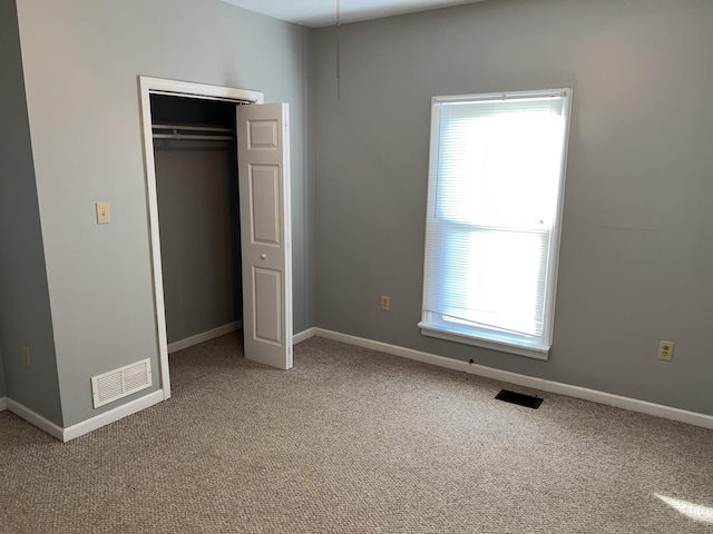 unfurnished bedroom featuring multiple windows, a closet, and carpet floors