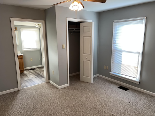 unfurnished bedroom featuring light carpet, a closet, and ceiling fan