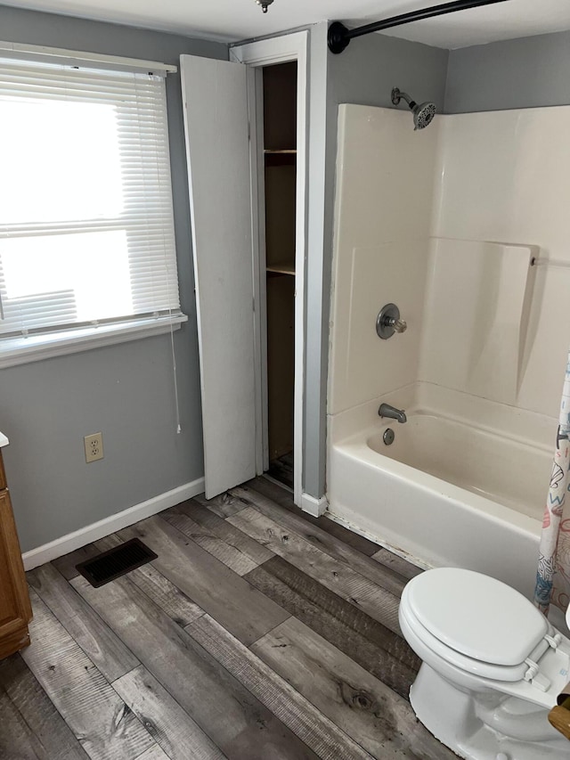 full bathroom featuring hardwood / wood-style floors, vanity, toilet, and shower / bath combo with shower curtain