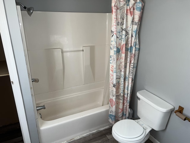 bathroom with hardwood / wood-style floors, shower / tub combo, and toilet