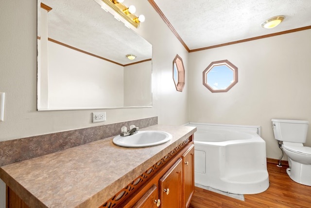 bathroom with toilet, a textured ceiling, vanity, a bath, and hardwood / wood-style floors