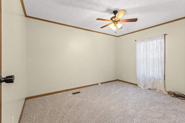 empty room featuring crown molding, light colored carpet, ceiling fan, and a textured ceiling