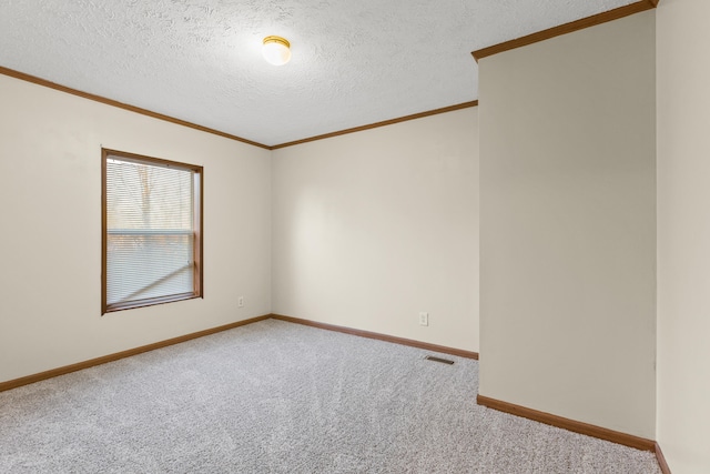 carpeted empty room with ornamental molding and a textured ceiling