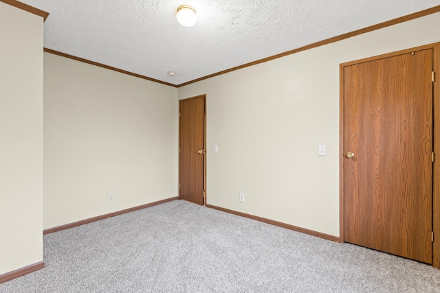 empty room with crown molding, light carpet, and a textured ceiling