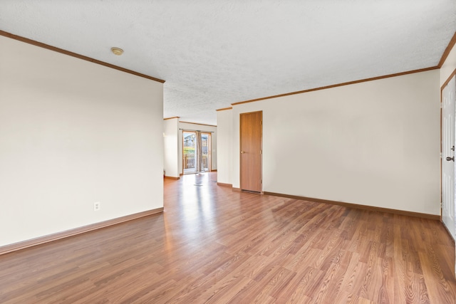 spare room featuring french doors, crown molding, light hardwood / wood-style flooring, and a textured ceiling