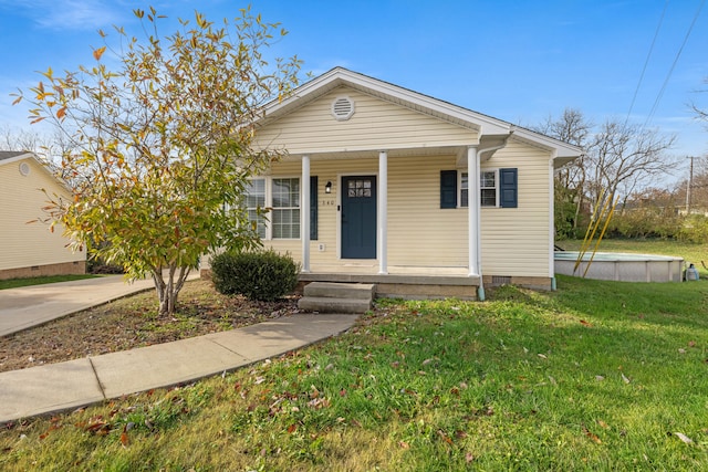 bungalow-style home featuring covered porch and a front lawn