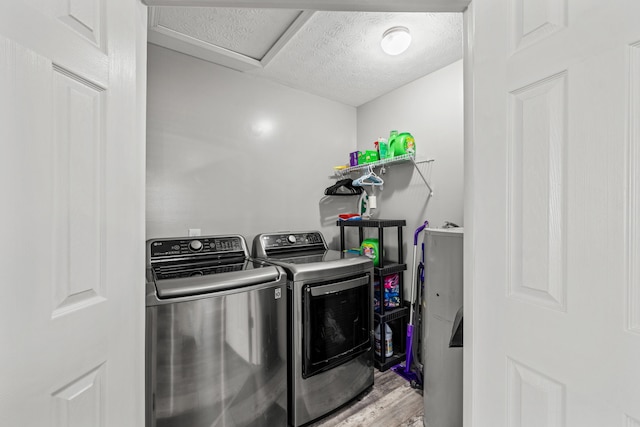 clothes washing area with hardwood / wood-style flooring and washer and clothes dryer