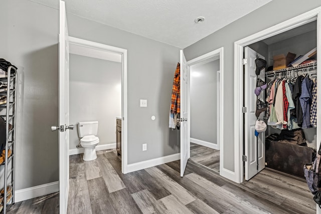 bathroom with vanity, wood-type flooring, a textured ceiling, and toilet