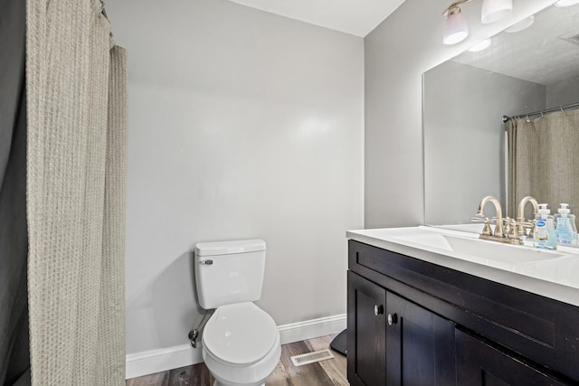 bathroom with vanity, hardwood / wood-style flooring, and toilet