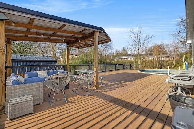 wooden deck with an outdoor living space and a fenced in pool