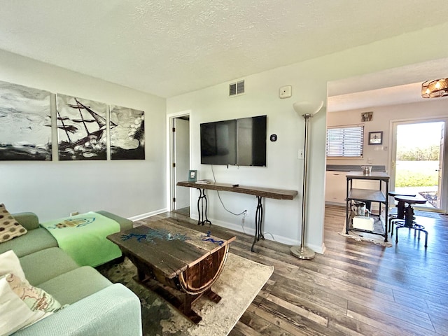 living room with a textured ceiling and dark hardwood / wood-style flooring