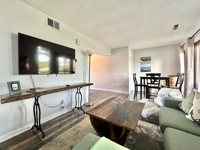 living room featuring a healthy amount of sunlight, a textured ceiling, and dark wood-type flooring