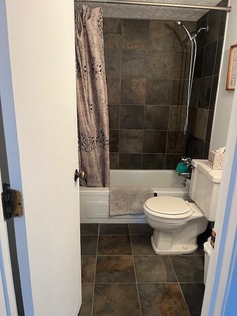 bathroom featuring shower / bath combo, toilet, and tile patterned floors