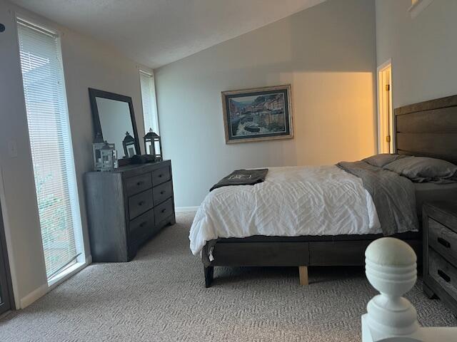 bedroom featuring light carpet and lofted ceiling