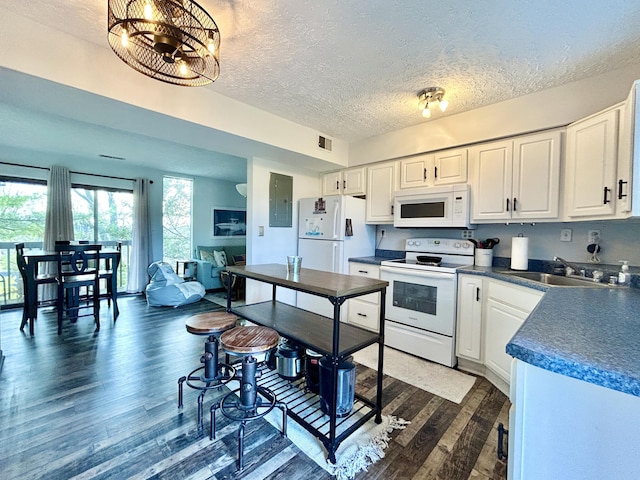 kitchen with sink, dark wood-type flooring, a textured ceiling, white appliances, and white cabinets