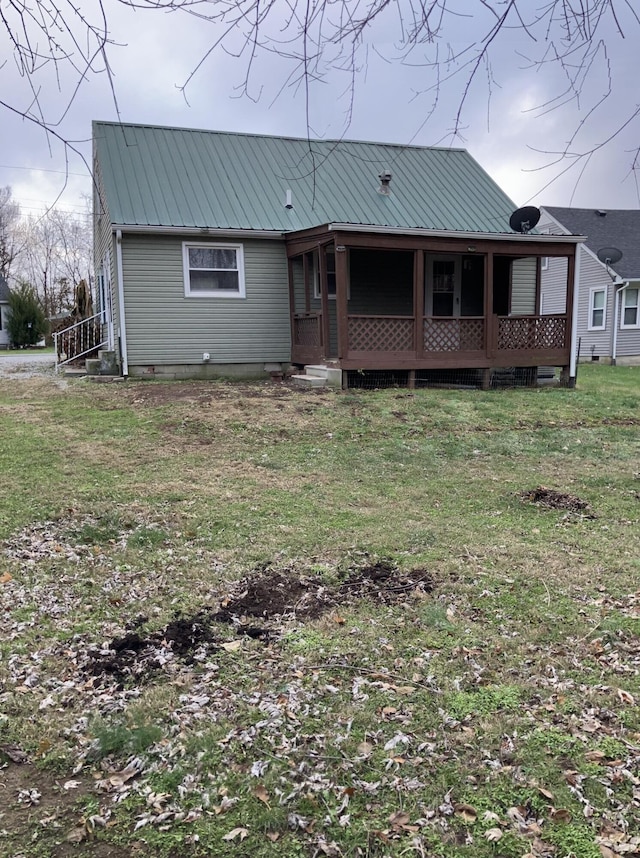 rear view of house featuring a lawn