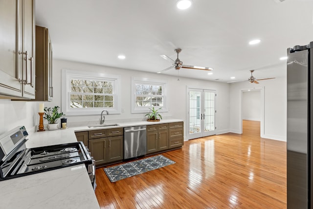 kitchen with french doors, sink, light hardwood / wood-style flooring, ceiling fan, and appliances with stainless steel finishes