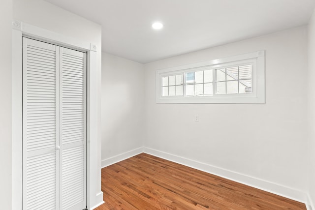 unfurnished bedroom with hardwood / wood-style floors and a closet