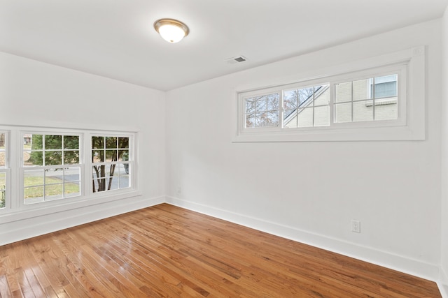 unfurnished room featuring hardwood / wood-style floors and a healthy amount of sunlight