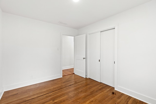 unfurnished bedroom featuring wood-type flooring and a closet