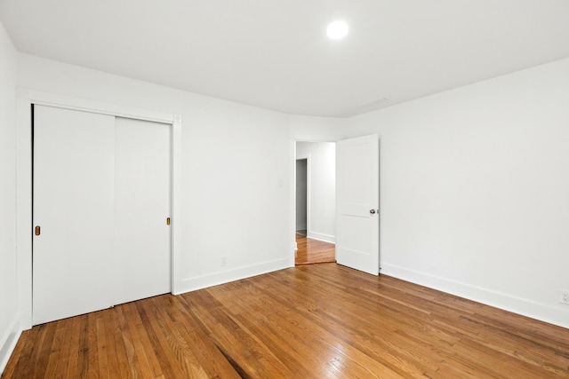 unfurnished bedroom with a closet and hardwood / wood-style floors