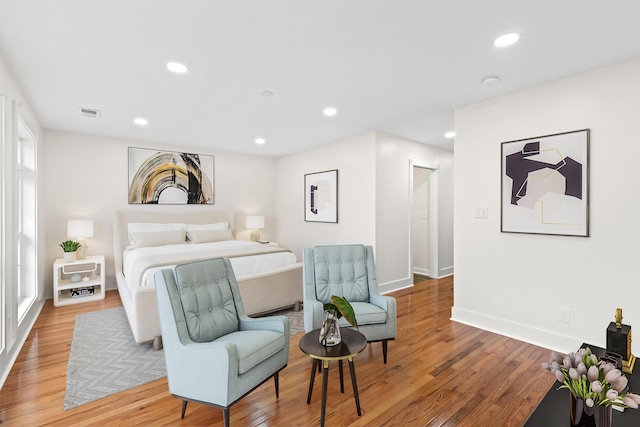 bedroom with hardwood / wood-style flooring and multiple windows