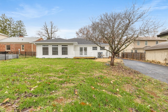 rear view of house with a deck and a lawn