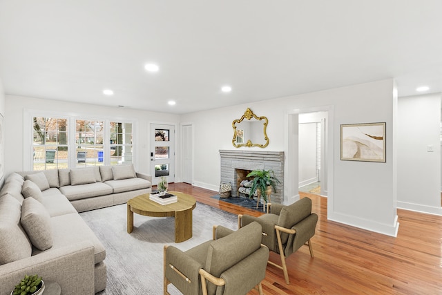 living room featuring light hardwood / wood-style floors and a brick fireplace