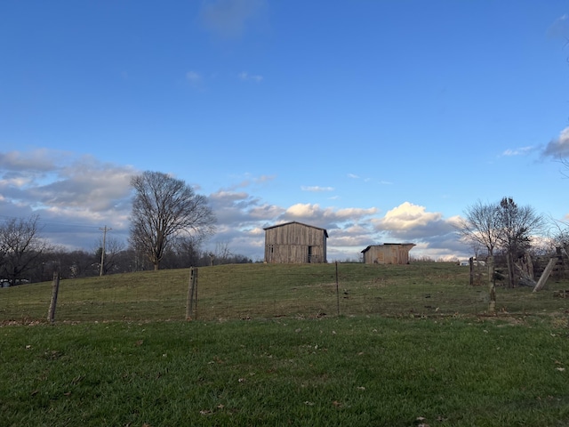 view of yard with a rural view and an outbuilding