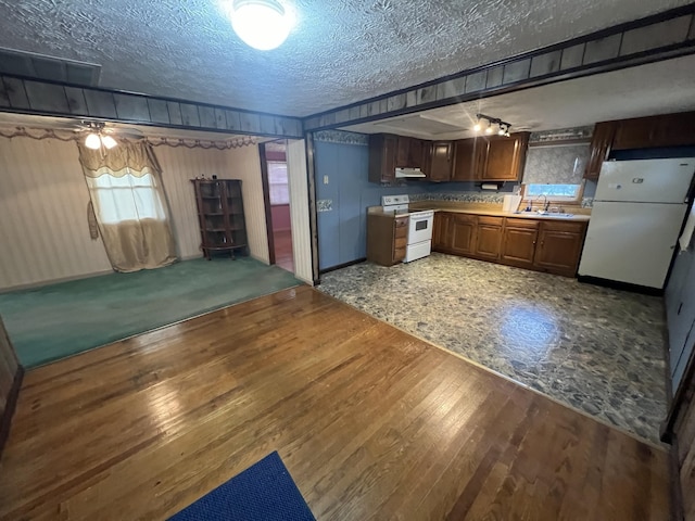 kitchen featuring hardwood / wood-style flooring, sink, white appliances, and a textured ceiling